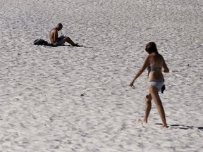 In this Jan. 24, 2019, photo, a man and a woman are on Glenelg Beach in Adelaide, Australia, as temperatures climb to 45 Celsius.