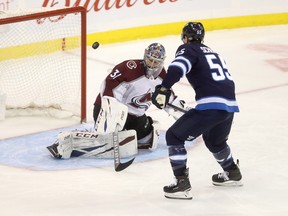 A shot by Winnipeg Jets' Mark Scheifele (55) bunches off of Colorado Avalanche goaltender Philipp Grubauer (31) before he knocked it out of the air and into the net during third period NHL hockey action in Winnipeg, Tuesday, Jan. 8, 2019. THE CANADIAN PRESS/Trevor Hagan ORG XMIT: WPGT124