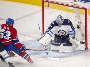 Jets goaltender Connor Hellebuyck makes the save against Montreal Canadiens defenceman Victor Mete during second period in Montreal on Thursday night. THE CANADIAN PRESS/Ryan Remiorz