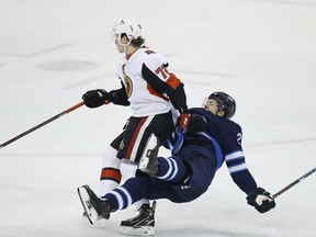 Winnipeg Jets' Jack Roslovic (28) gets checked by Ottawa Senators' Thomas Chabot (72) during first period NHL action in Winnipeg on Saturday, February 16, 2019. THE CANADIAN PRESS/John Woods ORG XMIT: JGW107