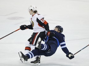 Ottawa Senators’ Thomas Chabot (left) takes down Jets’ Jack Roslovic during the first period on Saturday night in Winnipeg. (JOHN WOODS/THE CANADIAN PRESS)