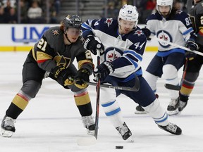 Winnipeg Jets defenseman Josh Morrissey (44) skates around Vegas Golden Knights center Cody Eakin (21) during the third period of an NHL hockey game Friday, Feb. 22, 2019, in Las Vegas.