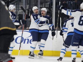 Winnipeg Jets defenseman Dmitry Kulikov (5) celebrates after left wing Nikolaj Ehlers, center right, scored against the Vegas Golden Knights during the first period of an NHL hockey game Friday in Las Vegas.