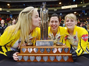 Manitoba skip Jennifer Jones kisses the trophy with teammates Shannon Birchard, (hidden) Jill Officer and Dawn McEwen after their win at the Scotties Tournament of Hearts in Penticton, B.C., on Sunday, Feb. 4, 2018. (THE CANADIAN PRESS/Sean Kilpatrick)