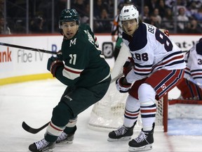 Jets’ Nathan Beaulieu (right) keeps an eye on Minnesota Wild forward Zach Parise during Tuesday night’s game in Winnipeg. Beaulieu was making his Jets debut. (KEVIN KING/WINNIPEG SUN)