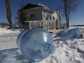 Empty 20 litre water bottles sit outside a house at Shoal Lake 40 waiting for pickup and refilling in February 2015.