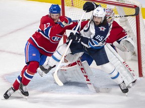 Montreal Canadiens defenceman Brett Kulak (17) checks Winnipeg Jets left wing Mathieu Perreault (85) in front of Montreal Canadiens goaltender Carey Price (31) during third period NHL hockey action Thursday, February 7, 2019 in Montreal. THE CANADIAN PRESS/Ryan Remiorz