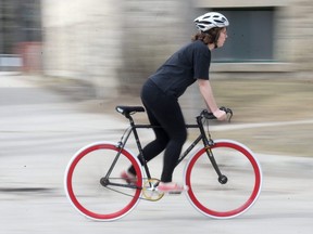 A cyclist cruises through Osborne Village. A report going to City of Winnipeg committee is recommending against creating a mandatory bike registration.