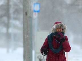 Laura Friesen uses ski poles to help her cross Portage Avenue at Bedson Street in Winnipeg, with blowing snow reducing visibility, on Monday. Winnipeggers awoke to find themselves under a winter storm warning with light snow and blowing snow reducing visibility and making the morning commute a challenge.