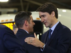 Prime Minister Justin Trudeau (right) embraces Mayor Brian Bowman during an announcement of funding for Winnipeg Transit projects at its Fort Rouge garage in Winnipeg on Tues., Feb. 12, 2019. Kevin King/Winnipeg Sun/Postmedia Network