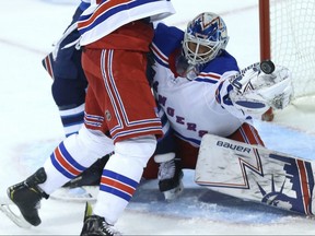 Rangers goaltender Henrik Lundqvist makes a glove save with traffic in front against the Jets on Tuesday night. Kevin King/Winnipeg Sun/Postmedia Network