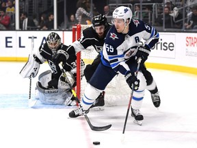 LOS ANGELES, CALIFORNIA - MARCH 18:  Mark Scheifele #55 of the Winnipeg Jets keeps the puck from Derek Forbort #24 of the Los Angeles Kings and Jack Campbell #36 during the first period at Staples Center on March 18, 2019 in Los Angeles, California. (Photo by Harry How/Getty Images)
