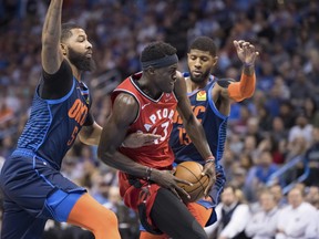 Toronto Raptors forward Pascal Siakam (43) drives to the basket between Oklahoma City Thunder forward Markieff Morris, left, and forward Paul George during Wednesday's game. (AP PHOTO)