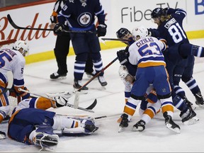 New York Islanders' Casey Cizikas (53) checks Winnipeg Jets' Mark Scheifele (55) over the back of Islanders' Adam Pelech (3) during Thursday's game. (THE CANADIAN PRESS)