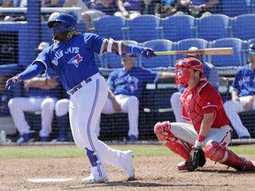 Toronto Blue Jays' Vladimir Guerrero Jr., left, follows through with a double as Philadelphia Phillies catcher Andrew Knapp looks on in the third inning of a spring training baseball game, Thursday, Feb. 28, 2019, in Dunedin, Fla.