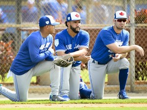 Toronto Blue Jays pitcher Marcus Stroman, left, Blue Jays infielder Devon Travis, centre, and Blue Jays outfielder Randal Grichuk, right, watch during baseball spring training in Dunedin, Fla., on Wednesday, February 20, 2019.