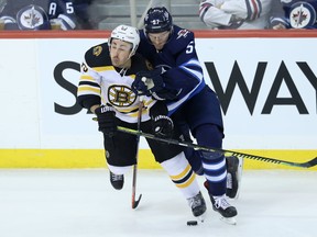 Boston Bruins’ Brad Marchand (left) and Jets’  Tyler Myers mix it up on Thursday night in Winnipeg. (KEVIN KING/WINNIPEG SUN)