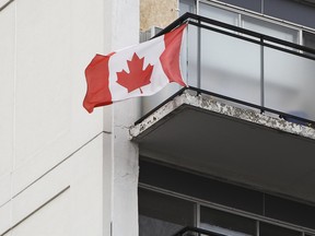 In this Sept. 28, 2011 file photo, a Canadian flag is seen flying from the balcony of an apartment building in Ottawa. (Andre Forget/Postmedia Network files)