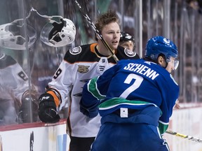 Anaheim Ducks' Max Jones, back, loses his helmet after being checked by Vancouver Canucks' Luke Schenn during the first period of an NHL hockey game in Vancouver, on Monday February 25, 2019. (THE CANADIAN PRESS/Darryl Dyck)