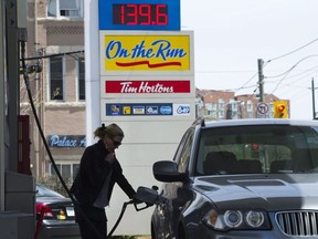 A woman pumps gas in Toronto on Tuesday, May 10, 2011. People in Manitoba, Ontario, Saskatchewan and New Brunswick will be paying more for gasoline and heating fuel Monday when the federal government's carbon tax begins in provinces that refused to impose their own emissions pricing.Nathan Denette / THE CANADIAN PRESS
