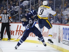 Winnipeg Jets' Mark Scheifele (55) checks Nashville Predators' Filip Forsberg (9) during second period NHL action in Winnipeg on Friday, March 1, 2019.