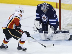 Connor Hellebuyck will start in goal when the Winnipeg Jets play host to the Johnny Gaudreau (13) and the Calgary Flames.
