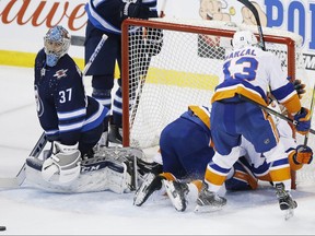 New York Islanders' Anders Lee (27), Mathew Barzal (13) and Jordan Eberle (7) celebrate Eberle's game winning goal on Winnipeg Jets goaltender Connor Hellebuyck (37) during third period NHL action in Winnipeg on Thursday, March 28, 2019. THE CANADIAN PRESS/John Woods ORG XMIT: JGW122