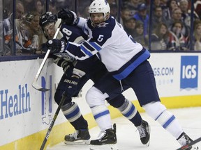 Winnipeg Jets' Dmitry Kulikov (right) checks Blue Jackets' Pierre-Luc Dubois. AP