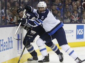 Winnipeg Jets' Dmitry Kulikov (right) checks Blue Jackets' Pierre-Luc Dubois during the second period in Columbus on Sunday night. AP