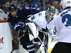 Winnipeg Jets Bryan Little (left) is squeezed against the boards by San Jose Sharks goaltender Aaron Dell in Winnipeg on Tues., March 12, 2019. Kevin King/Winnipeg Sun/Postmedia Network