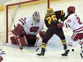 Wisconsin goaltender Kristen Campbell (35) knocks the puck away after a shot on goal by Minnesota's Sarah Potomak (26) during the third period in the NCAA Division I women's Frozen Four hockey championship game, Sunday, March 24, 2019, in Hamden, Conn. (AP Photo/Stephen Dunn) ORG XMIT: CTSD115