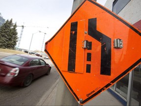 A car drives past a construction sign. Winnipeg plans to use a one-time boost from the feds for road renewal and active transportation. Ian Kucerak/Postmedia Network files