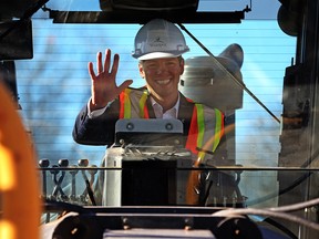 Mayor Brian Bowman sits in the cab of a grader after visiting the site of an asphalt reconstruction project on Ravenhill Road in the Valley Gardens in October 2015.