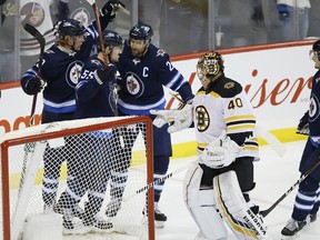 Winnipeg Jets' Patrik Laine (29), Mark Scheifele (55), Blake Wheeler (26) and Jacob Trouba (8) celebrate Scheifele's goal against Boston Bruins goaltender Tuukka Rask last night. (The Canadian Press)