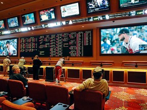In this Monday, May 14, 2018, file photo, people make bets in the sports book at the South Point hotel and casino in Las Vegas.