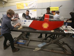 Red River College students work on SpaRRCky, a battery-electric car they hope will land them on the podium next month at Sonoma Raceway in California. Chris Procaylo/Postmedia