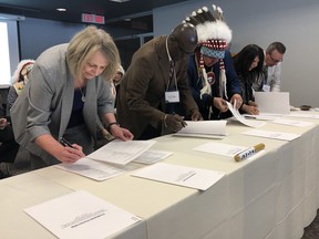 (Left to right) East St. Paul Mayor Shelley Hart, Stonewall Mayor Clive Hinds, Chief Lance Roulette, Chief Debrah Smith and Selkirk Mayor Larry Johannson sign as municipal leaders of the Winnipeg METRO Region (WMR) and the Chiefs of the Southern Chiefs’ Organization (SCO) made history on Friday at Lower Fort Garry National Historic Site in St. Andrews, Man. - the location of the historic signing of Treaty 1 in 1871, 148 years ago.