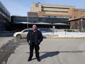 A security guard stands outside the Sherbrook Street entrance at Health Sciences Centre in Winnipeg on Monday.