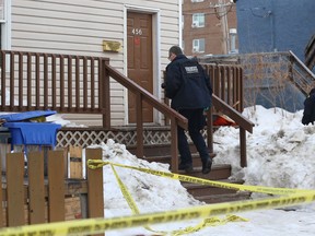 Forensics officers from the Winnipeg Police Service investigate at the scene of a homicide in the 400 block of Langside Street on Monday. Police say a man was assaulted at about 7 p.m. on Sunday night, and later died in hospital.