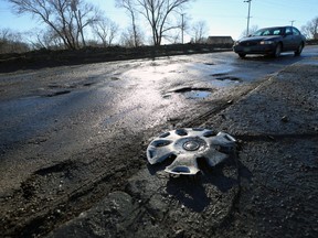 A busted hubcap lies on the median as a vehicle approaches a potholed section of Empress Street in Winnipeg on Wed., March 20, 2019. Kevin King/Winnipeg Sun/Postmedia Network
