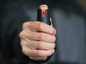 Man holding pepper spray container in his hand.