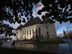 A pedestrian walks past the Supreme Court of Canada in Ottawa, Oct. 18, 2013. A murderer won't get a chance to argue in the Supreme Court that his conviction should be overturned because a rap lyric he wrote was improperly allowed into evidence.