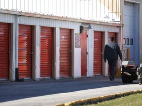 Company security staff walk past storage lockers in Winnipeg on October 21, 2014. A woman convicted of hiding the remains of six babies in a U-haul storage locker has had her sentence reduced to three years.
