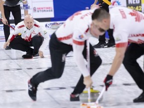 Canada skip Kevin Koe watches lead Ben Hebert and second Colton Flasch sweep his rock during their game against Germany at the Men's World Curling Championship in Lethbridge, Alta. on Tuesday, April 2, 2019.