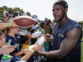 In this Aug. 6, 2018, file photo, Seattle Seahawks defensive end Frank Clark signs autographs following NFL training camp, in Renton, Wash.