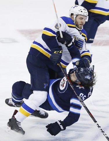 Winnipeg Jets' Mathieu Perreault (85) gets checked by St. Louis Blues' Joel Edmundson (6) during third period NHL playoff action in Winnipeg on Wednesday, April 10, 2019. THE CANADIAN PRESS/John Woods