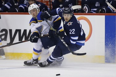 Winnipeg Jets centre Par Lindholm (22) steals the puck from St. Louis Blues centre Tyler Bozak (21) during second period NHL playoff action in Winnipeg on Wednesday, April 10, 2019. THE CANADIAN PRESS/John Woods