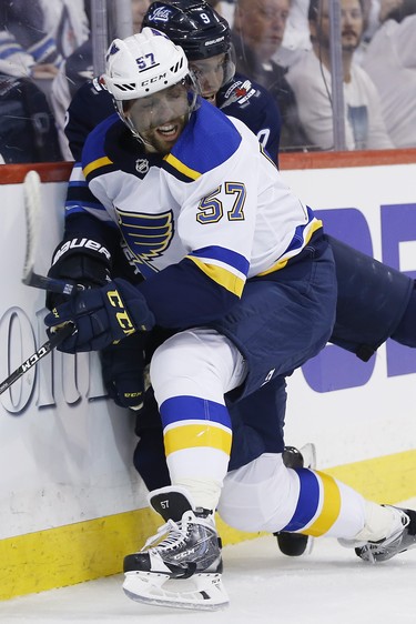 St. Louis Blues' David Perron (57) checks Winnipeg Jets' Andrew Copp (9) during first period NHL playoff action in Winnipeg on Wednesday, April 10, 2019. THE CANADIAN PRESS/John Woods