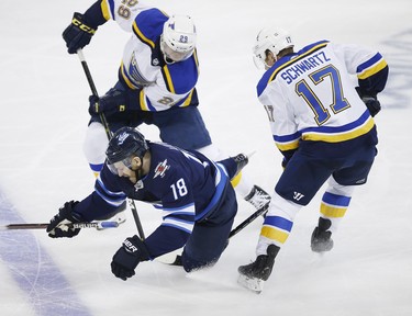 Winnipeg Jets' Bryan Little (18) gets tripped up by St. Louis Blues' Jaden Schwartz (17) during third period NHL playoff action in Winnipeg on Wednesday, April 10, 2019. THE CANADIAN PRESS/John Woods