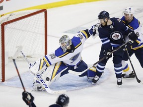 St. Louis Blues goaltender Jordan Binnington (50) stops the shot from Winnipeg Jets' Mark Scheifele (55) in the late seconds of third period NHL playoff action in Winnipeg on Wednesday, April 10, 2019. THE CANADIAN PRESS/John Woods